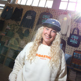 Person wearing a white sweatshirt with orange text in a store setting